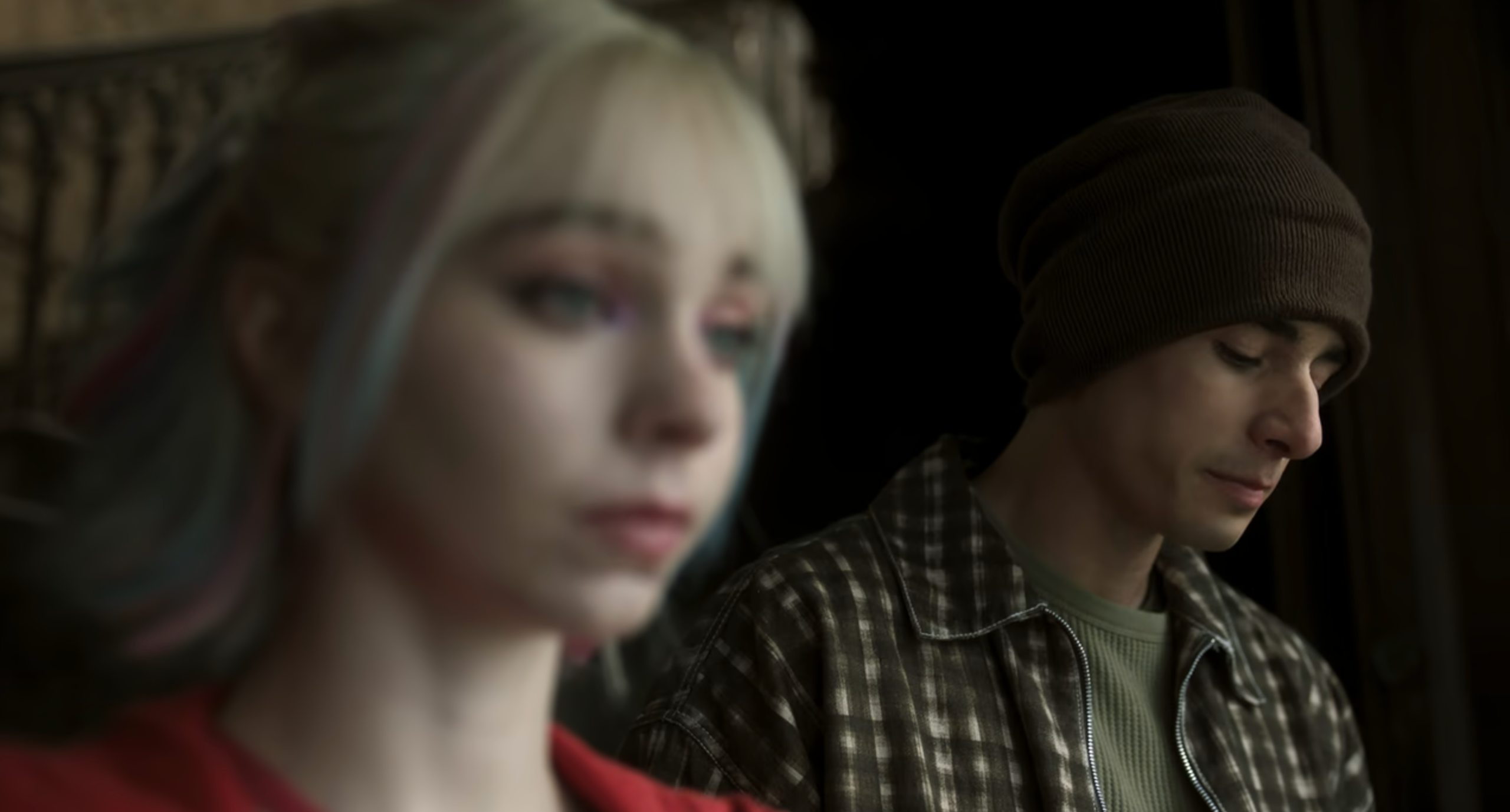 Enid Sinclair and Ajax Petropolus in a quiet, emotional moment as they reconcile. Enid is in soft focus in the foreground with pastel-colored hair and a concerned expression, while Ajax stands in focus behind her, looking down with a solemn face and wearing a beanie and plaid shirt.