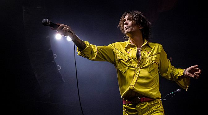 Justin Hawkins of The Darkness extending his microphone to the crowd