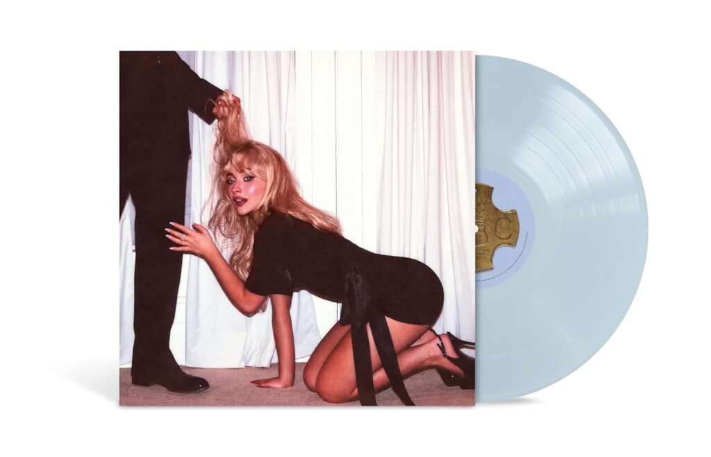 Vinyl record of Sabrina Carpenter’s “Man’s Best Friend” album. The cover shows her on all fours in a black dress, looking at the camera while a suited man’s hand pulls her hair. The vinyl is light blue, slightly pulled out from the sleeve. The image plays with themes of submission and provocation.