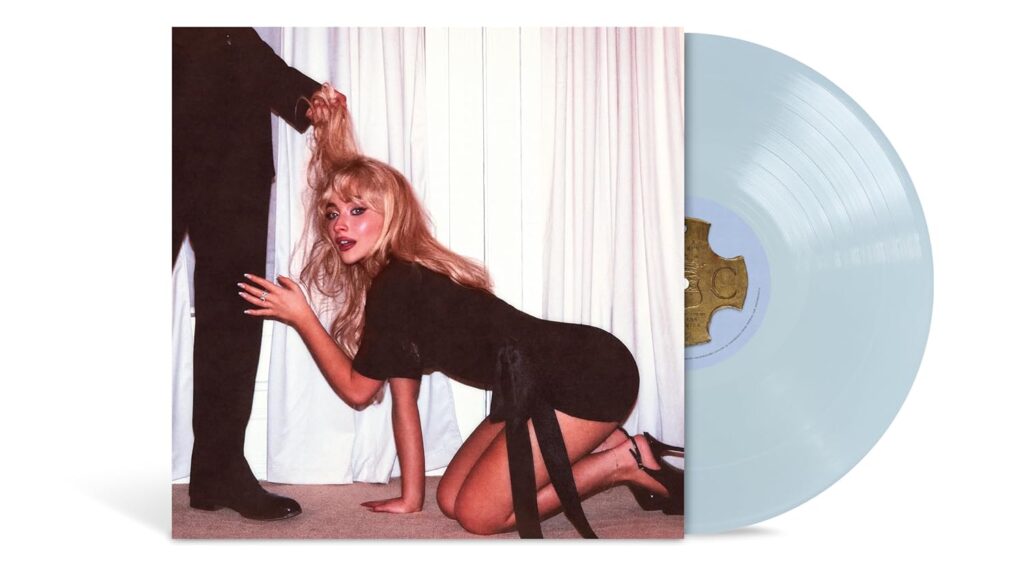 Vinyl record of Sabrina Carpenter’s “Man’s Best Friend” album. The cover shows her on all fours in a black dress, looking at the camera while a suited man’s hand pulls her hair. The vinyl is light blue, slightly pulled out from the sleeve. The image plays with themes of submission and provocation.
