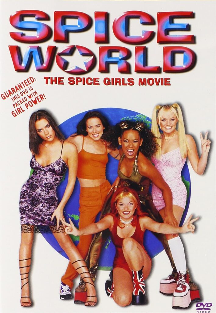 DVD cover of Spice World: The Spice Girls Movie. The five members of the Spice Girls pose playfully in front of a globe—Victoria Beckham, Melanie C, Mel B, Emma Bunton, and Geri Halliwell—each wearing their signature 1990s style outfits. The title “SPICE WORLD” appears in large metallic red, white, and blue letters with a star in the “O.” A tagline on the left reads “Guaranteed: This DVD is packed with Girl Power!”