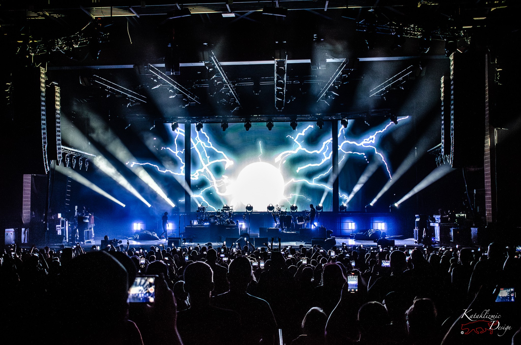 The Offspring’s stage lit with blue lightning and a glowing orb on screen, as the crowd anticipates guitarist Noodles’ entrance.
