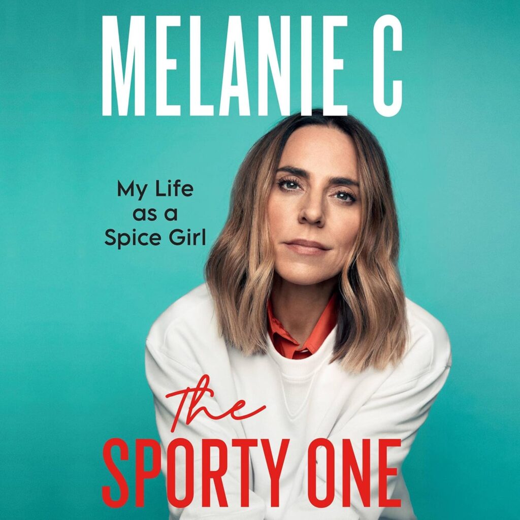 Cover of Melanie C’s memoir The Sporty One: My Life as a Spice Girl. It features Melanie C sitting against a teal background, wearing a white sweatshirt over a red collared shirt. Her hair is shoulder-length and softly waved, and she looks directly at the camera with a calm, introspective expression. The title text appears in large white and red lettering.