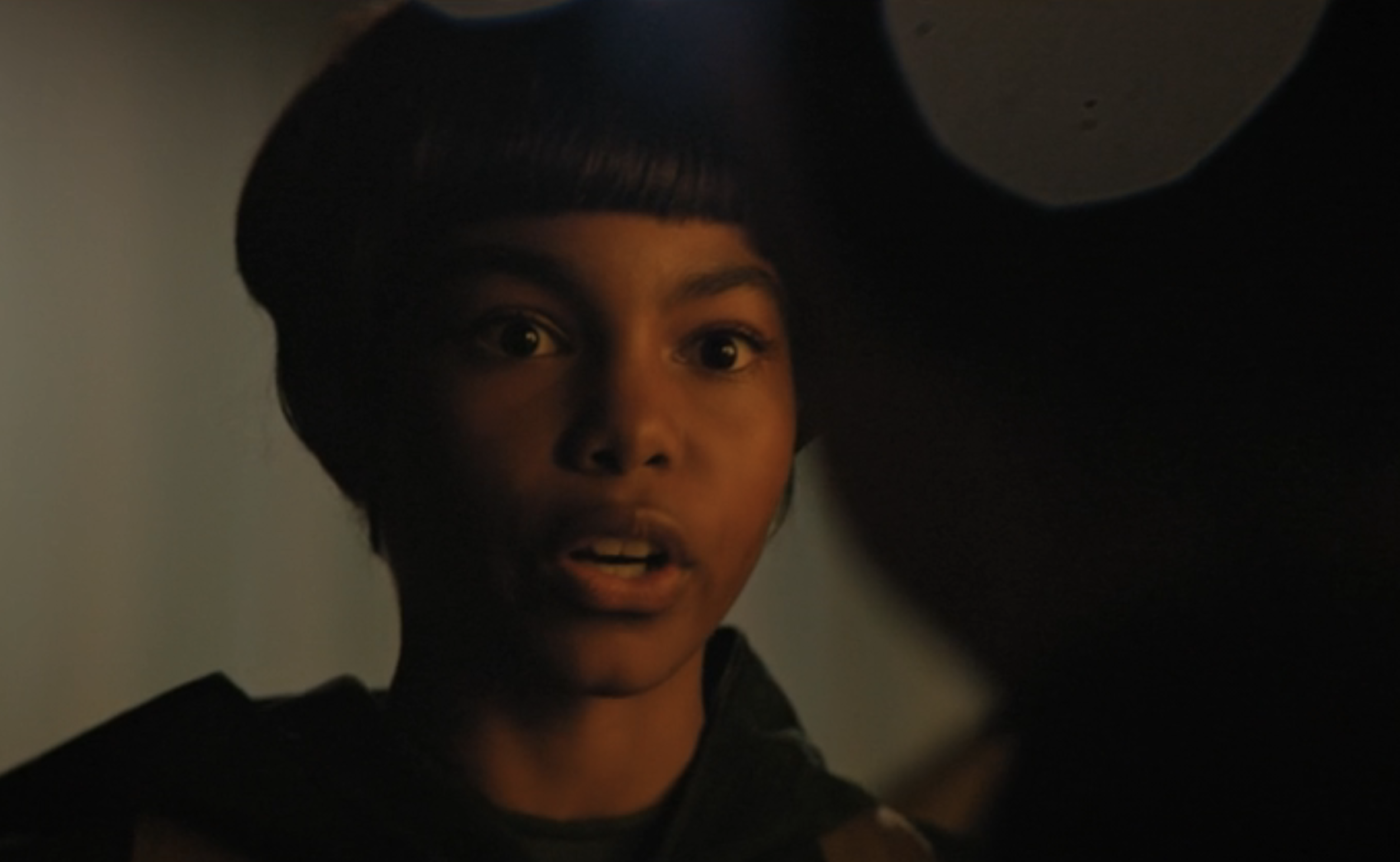 A young Michael Burnham in Star Trek: Discovery speaks with wide eyes, her expression urgent and emotional.