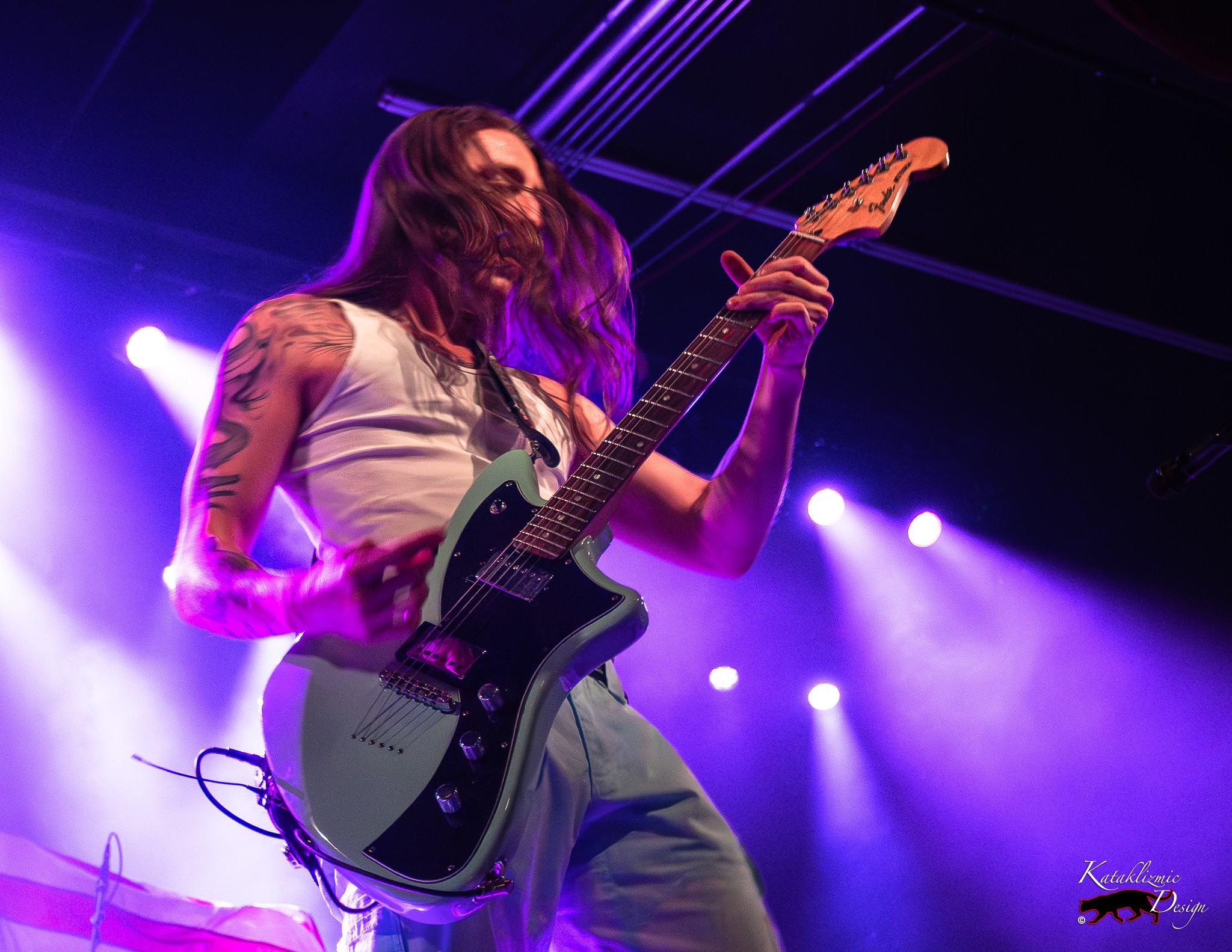 Arrows in Action frontman Victor Viramontes-Pattison plays guitar under purple stage lights during the band’s opening set.