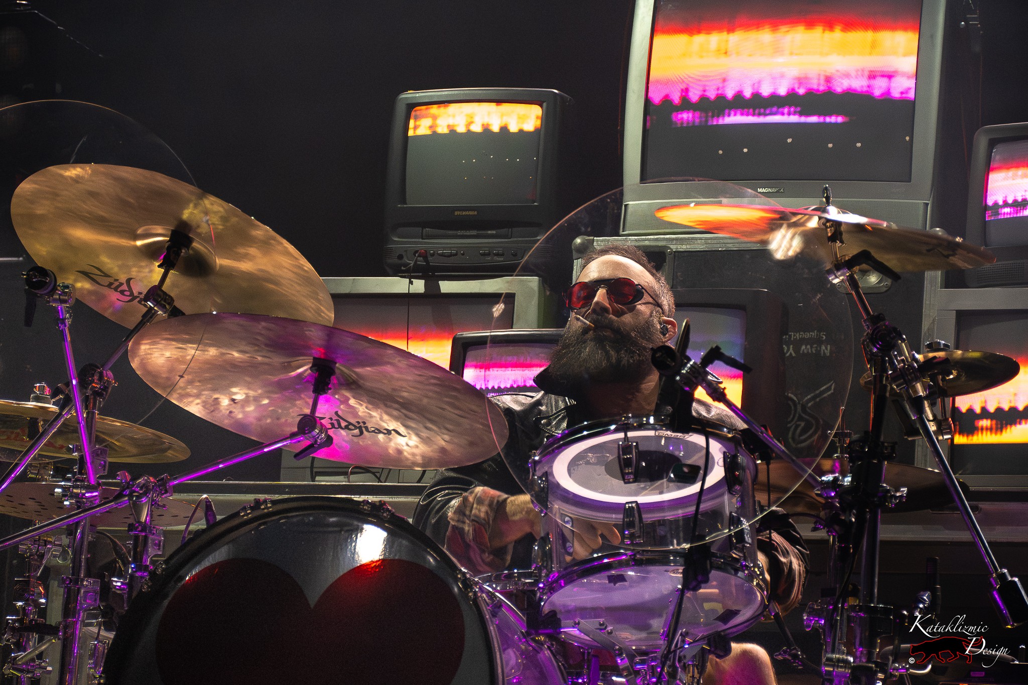 BOYS LIKE GIRLS drummer John Keefe performs behind the kit surrounded by glowing CRT televisions.