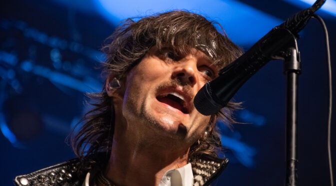 BOYS LIKE GIRLS lead singer Martin Johnson performing at Marquee Theatre, singing into a microphone under blue stage lights.