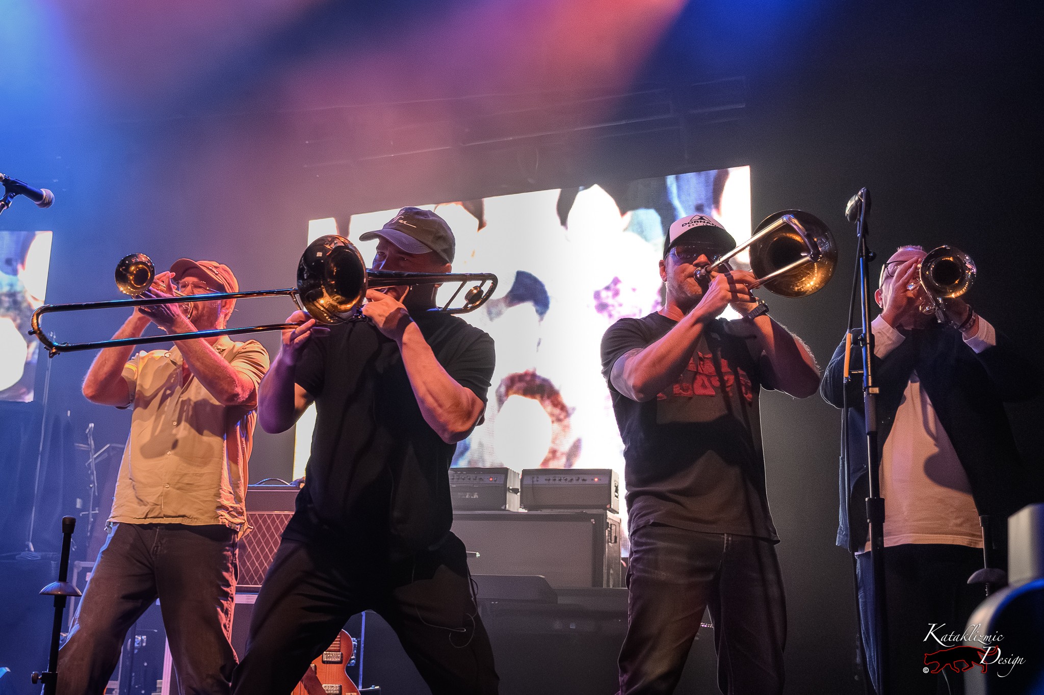 Broken Social Scene’s horn section plays trombone and trumpet together onstage.