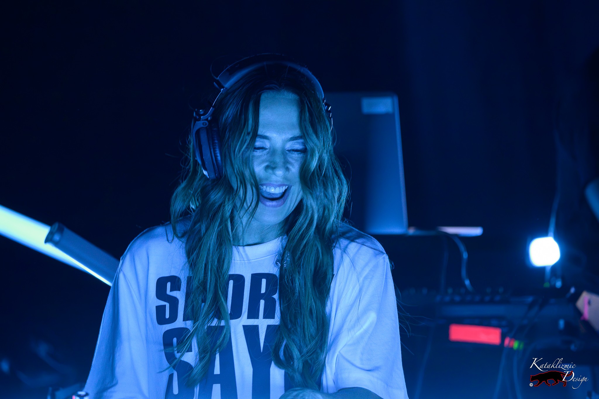 Melanie C smiles broadly while wearing headphones behind the DJ decks during The Melanie C World Tour at House of Blues San Diego.