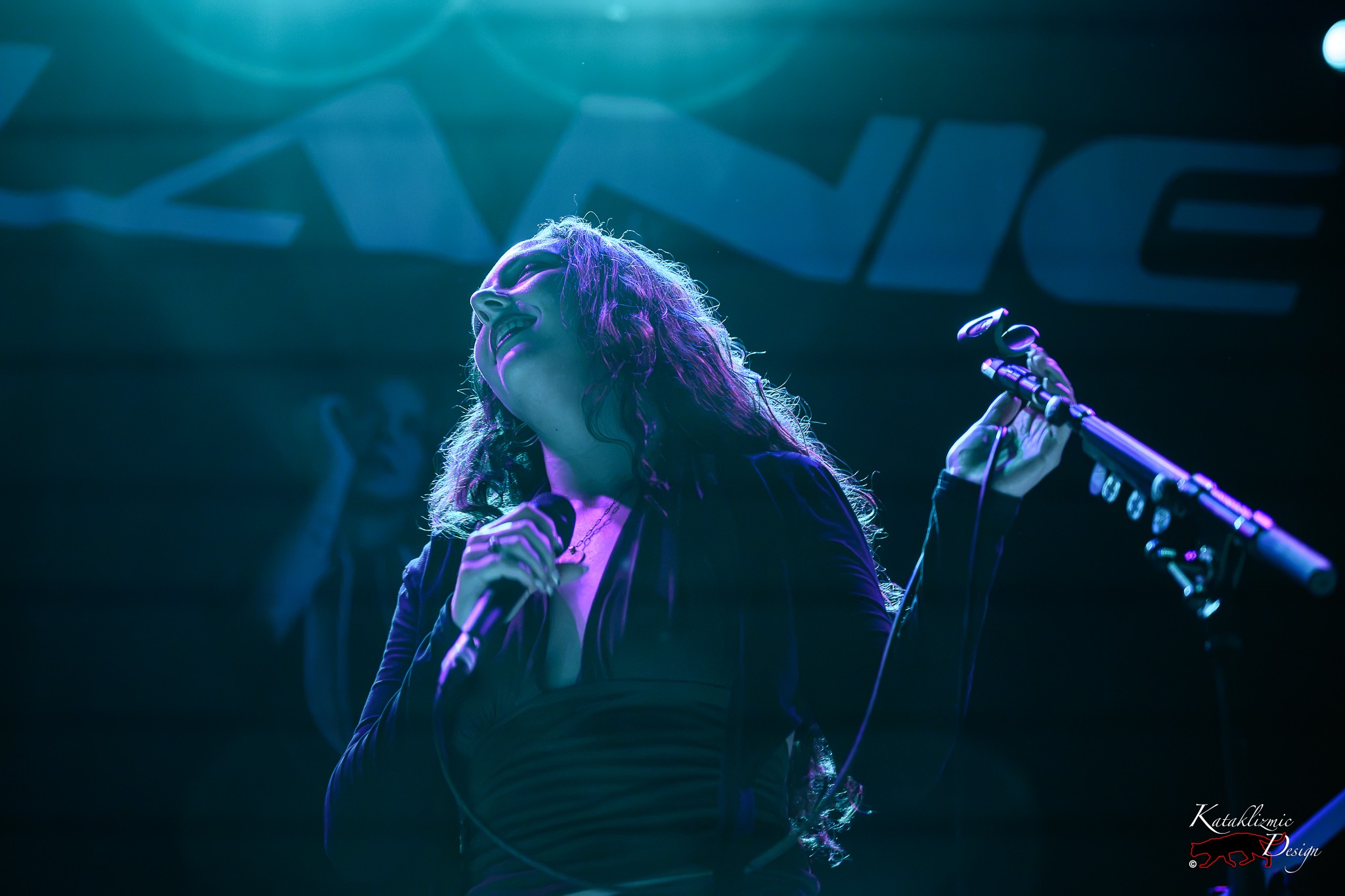 Sur Back smiles with her head tilted back beneath dreamy blue and violet lighting during her House of Blues San Diego performance.